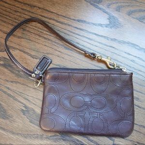 Brown leather Coach wristlet with embroidered logo